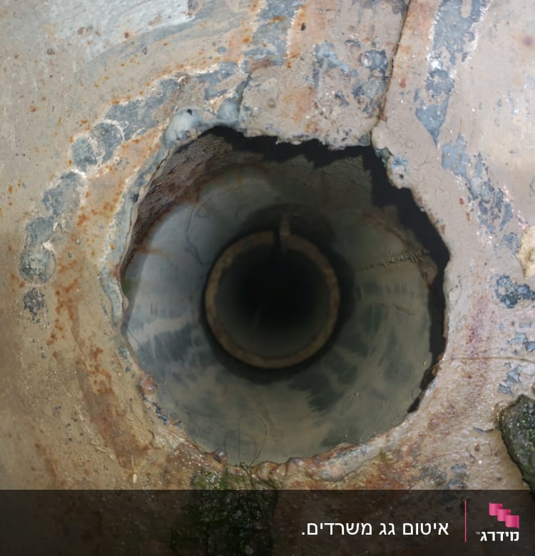 חור בצינור מתכת חלוד עם קצוות לא אחידים